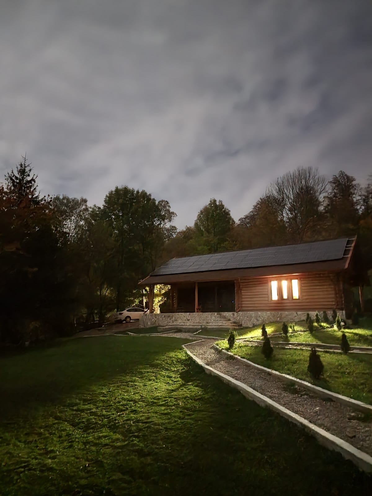 Restaurantul și aleea din curte, iluminate seara